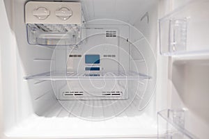 Open empty new white refrigerator inside fridge with shelves