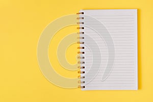 Open empty notebook on a yellow background. Top view