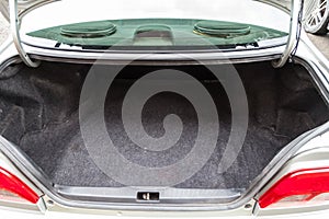 Open empty trunk of a car sedan close-up after washing and vacuuming with a clean mat of special black material ready for loading