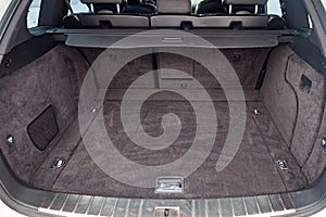 Open empty trunk of a car suv close-up after washing and vacuuming with a clean mat of special black material ready for loading