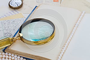Open empty vintage book with finding glass