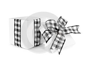 Open empty white Christmas gift box with black and white buffalo plaid bow and ribbon isolated on white