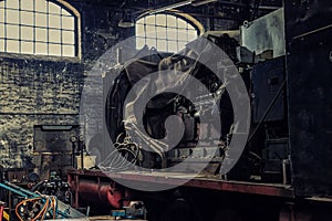 The open engine of an old electric locomotive in an abandoned workshop