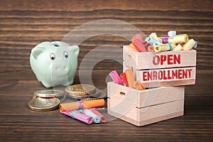 Open Enrollment concept. Colored papr scrolls in wooden boxes on dark wooden background