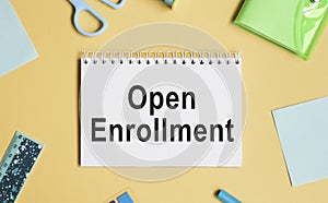 Open Enrollment. Notebooks, pen and colored pencils on a wooden table