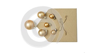 Open envelope from craft paper from which Christmas golden balls have spilled out