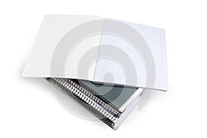 Open exercise book on a stack of other exercise books