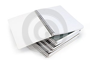 Open exercise book on stack of other exercise books