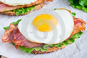 Open face sandwich with egg, bacon, tomato and lettuce