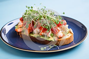 an open-faced lobster toast sandwich on a light blue plate