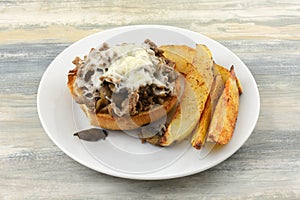 Open faced sliced beef sandwich with potato wedges