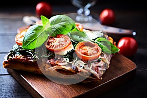 Open-faced toasted cheese sandwich with cherry tomatoes, spinach and fresh basil.