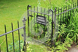 Open fence and a warning, private gardens no admittance. photo