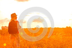 Woman silhouette waiting for summer sun on meadow