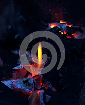 Open fire barbecue background: Burning charcoal with hot flame close up. Blue and orange. Camp fire, grill, traditional stove