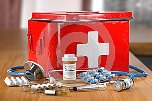 Open first aid kit with stethoscope, pills and smedicationon the table