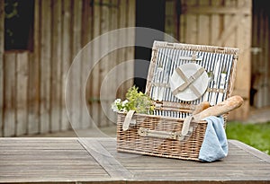 Open fitted wicker picnic hamper on a garden table