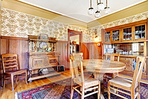 Open floor plan antique dining area with wooden pannel trim