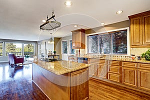 Open floor plan. Kitchen room interior with island and granite counter top.