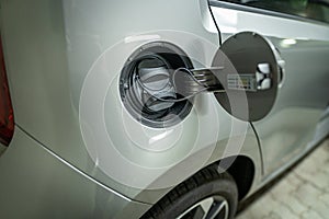 Open fuel cap of a electric car which is ready to get recharged with green power eco electricity.