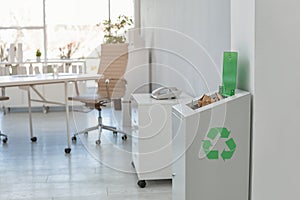 Open full trash bin in modern office. Waste recycling