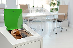 Open full trash bin in modern office. Waste recycling