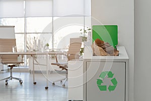 Open full trash bin in modern office. Waste recycling