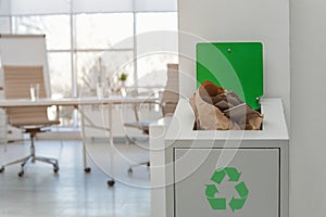 Open full trash bin in modern office. Waste recycling