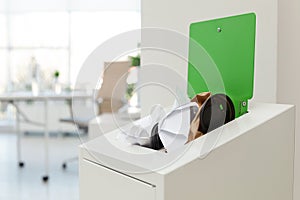 Open full trash bin in modern office. Waste recycling