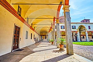 The open gallery with arcades of Basilica of Sant\'Ambrogio complex in Milan, Italy