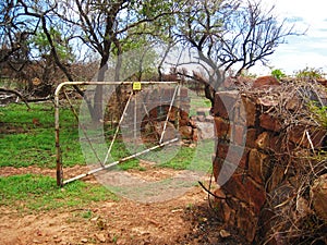 OPEN GATE ENTRANCE TO THE PRELLER CEMETERY IN A DRYWALL ROCK ENCLOSURE