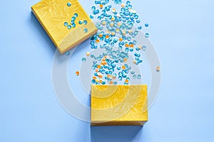 Open gift box with party confetti on a blue background. Flat lay