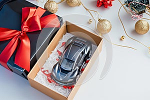 open gift box with a remotecontrol car inside, on a white backdrop