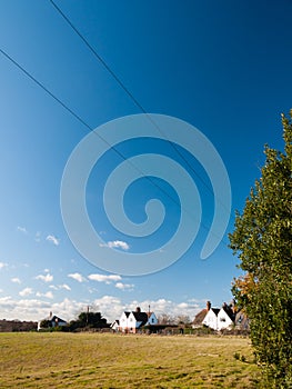 open grass land green plain farm land country blue sky farm houses white