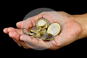 Open Hand Holding a Selection of Coins on Black Background