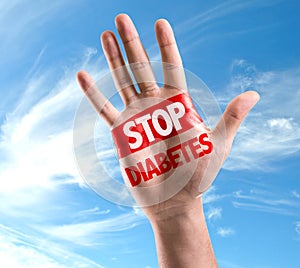 Open hand raised with the text: Stop Diabetes on sky background