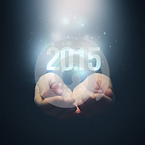 Open hands holding number 2015. Happy New Year.