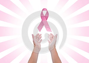 Open hands with pink ribbon for breast cancer awareness