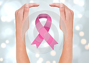 Open hands with pink ribbon for breast cancer awareness