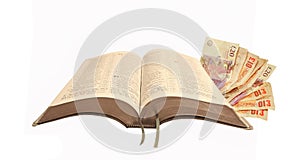 Open holy bible book scripture money cash paper notes greed god jesus religion parable christ jehovah jah yahweh