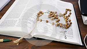 Open Holy Bible on brown wood table background