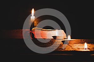 Open Holy Bible and candle on a old oak wooden table.