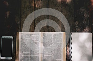 Open holy bible on wood table with sunlight.Sunday reading