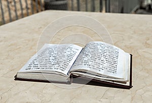 The open  holy book of Jews with the text of prayers in Hebrew - Tehelim, lies on a table near the Western Wall in the old city.