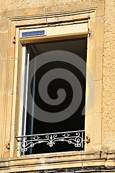 Open house window with decorative iron retainer