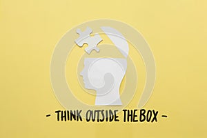 open human brain with jigsaw piece near think outside box message. High quality photo