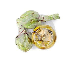 Open jar of delicious artichokes pickled in olive oil and fresh vegetables on white background, top view