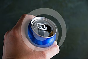 Open jar of delicious cold soda drink in human hand on dark background. Feeling cool on a hot summer day