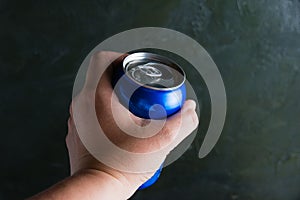 Open jar of delicious cold soda drink in human hand on dark background. Feeling cool on a hot summer day