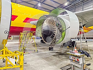 Open jet engine in hangar showing mechanical parts during aircraft maintenance work photo